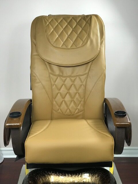 A front view of a cappuccino pedicure chair with seat covers